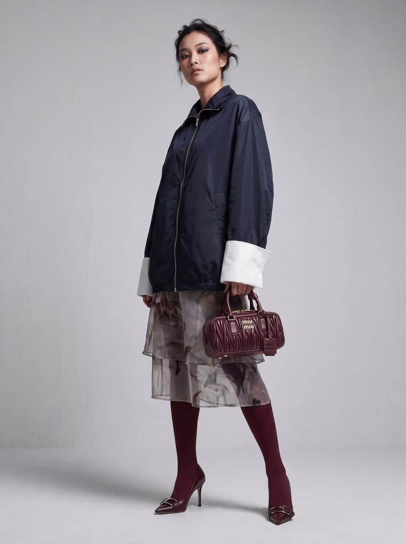 The same model holding the burgundy handbag after Accessories Try-On.