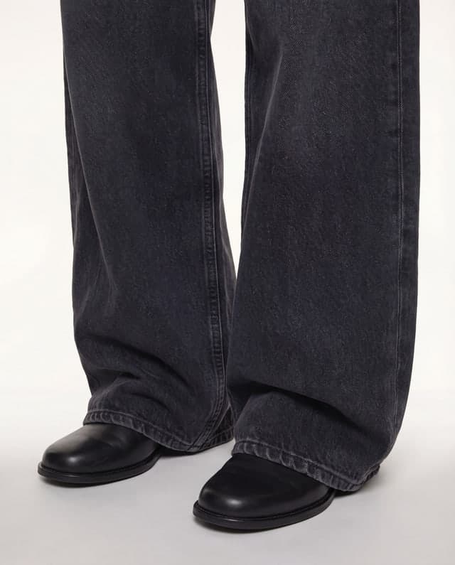 Detail view of the trouser hem and shoes.