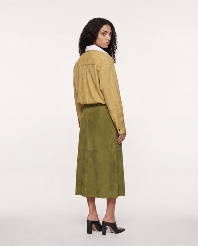 Back view preserving the same person, clothes and studio direction.